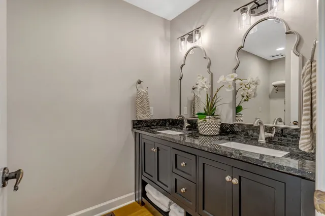 a bathroom with a granite countertop sink and a mirror