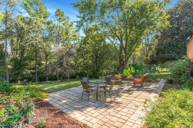 a view of a house with a big yard and large trees