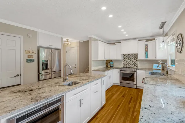 a kitchen with granite countertop kitchen island cabinets and stainless steel appliances
