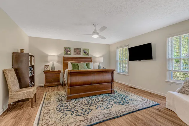 a bedroom with a bed flat screen tv and a window
