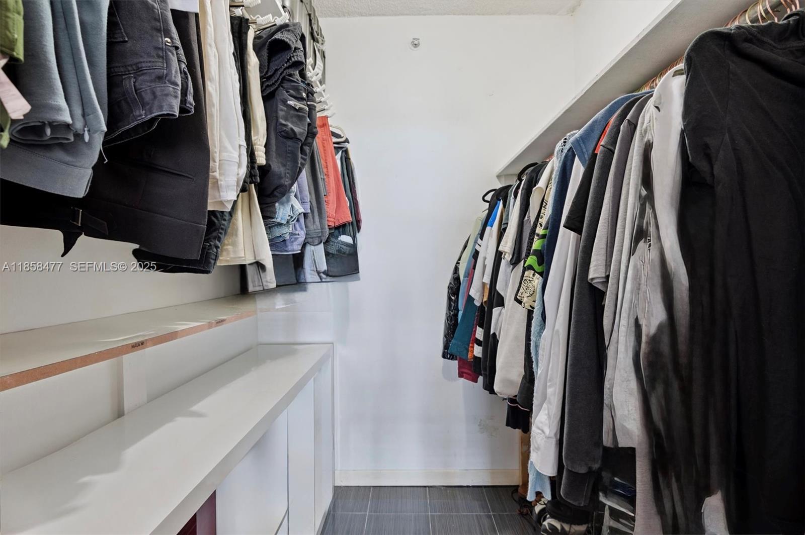 5601 Collins Avenue, Unit 820 Miami Beach, FL 33140 - Photo 11 of 23 a view of walk in closet with clothes and shoes