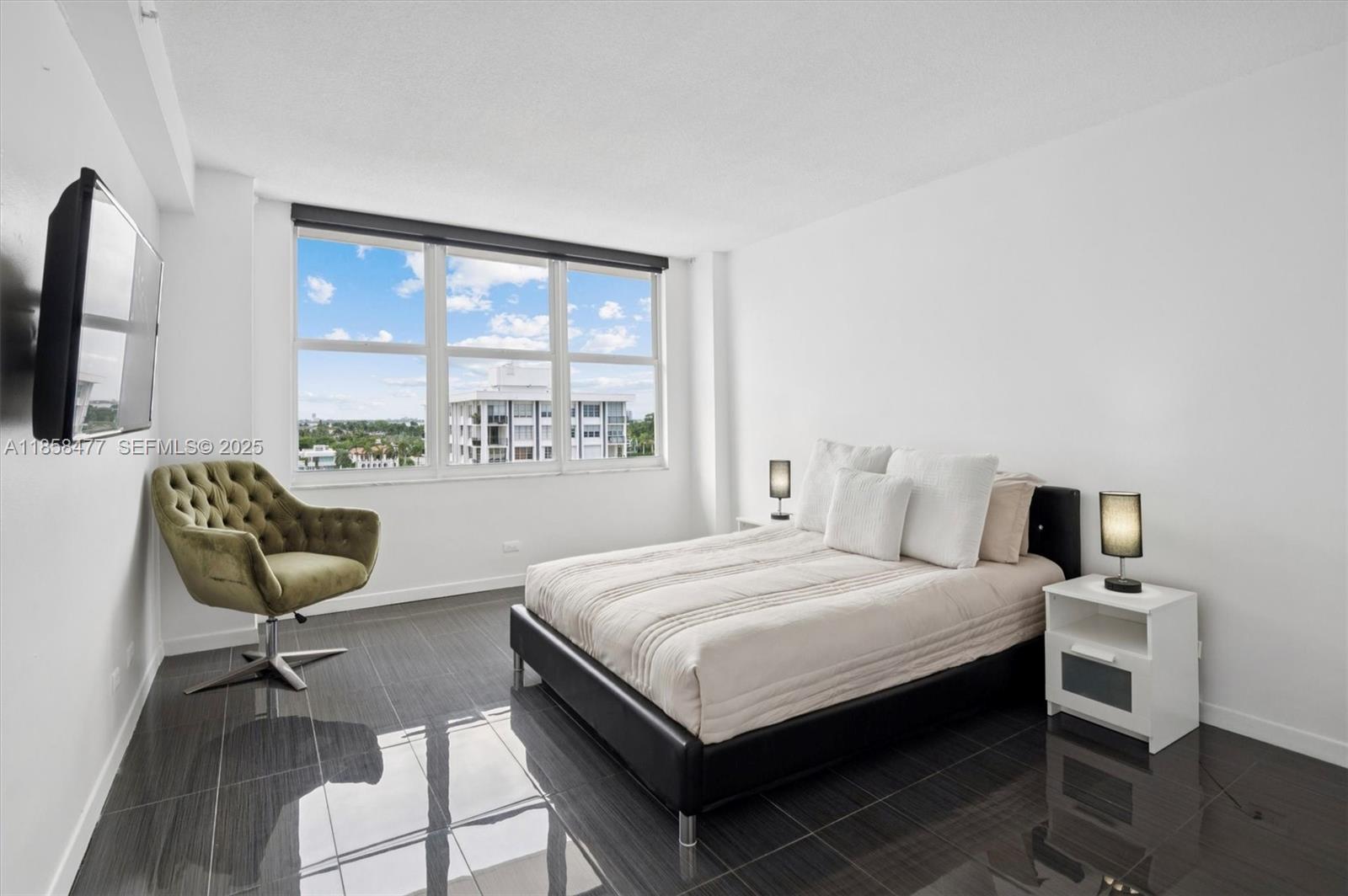 5601 Collins Avenue, Unit 820 Miami Beach, FL 33140 - Photo 13 of 23 a bedroom with a bed wooden floor and a large window
