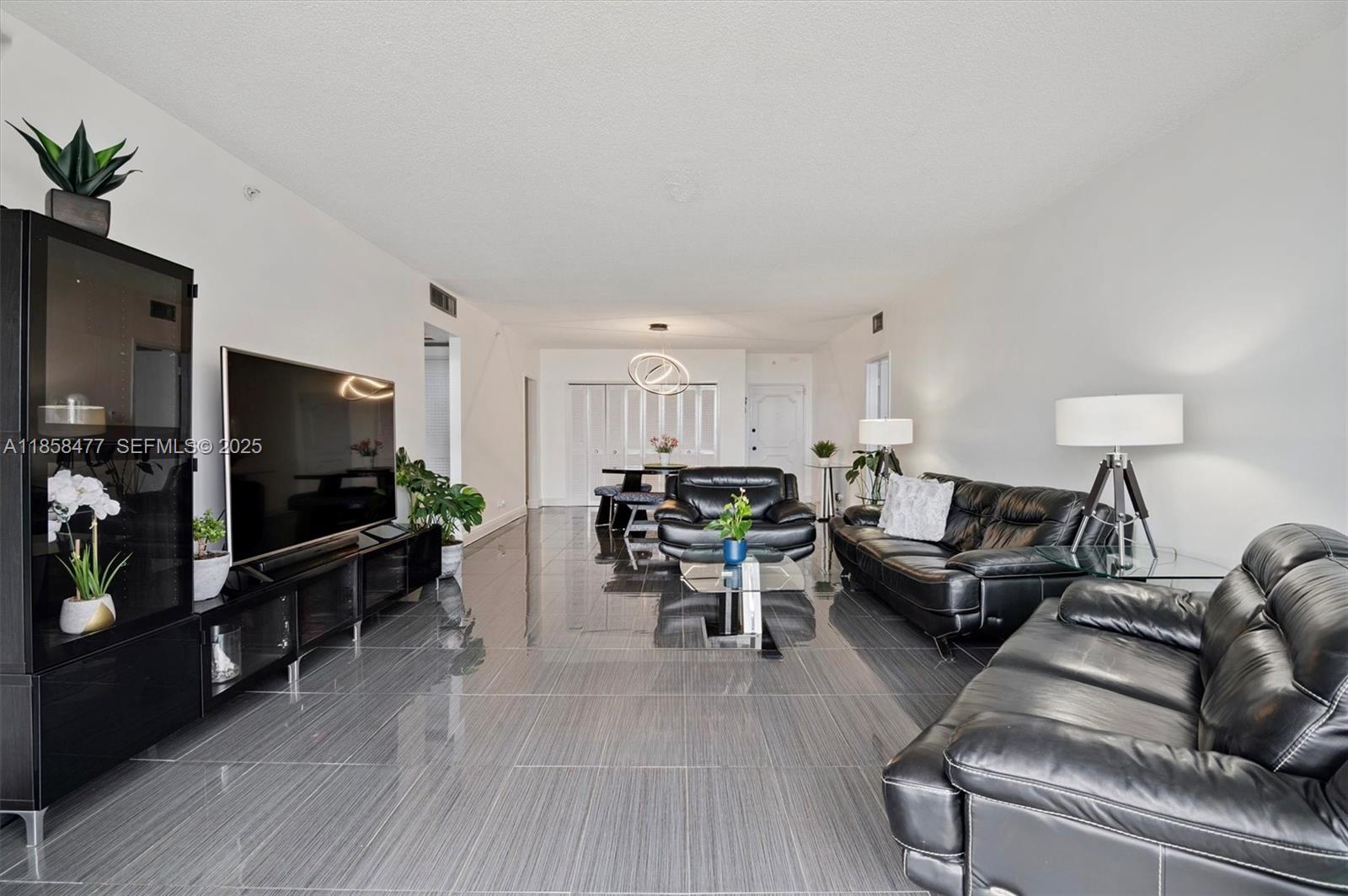 5601 Collins Avenue, Unit 820 Miami Beach, FL 33140 - Photo 7 of 23 a living room with furniture and a flat screen tv