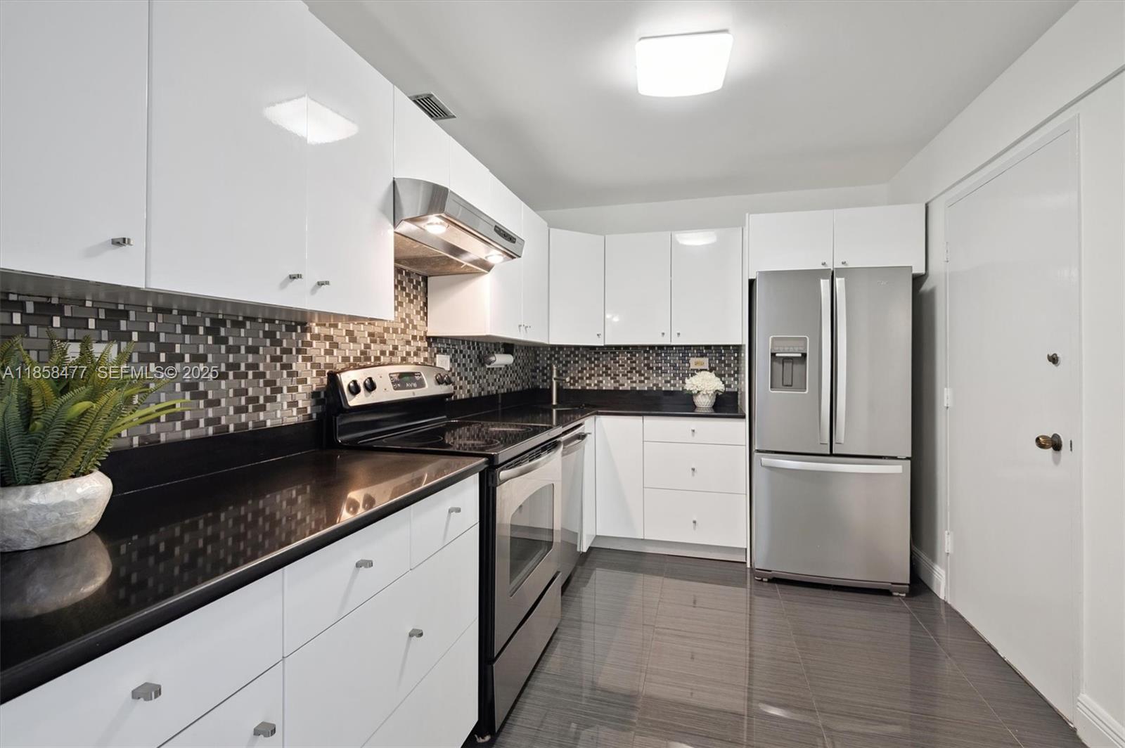 5601 Collins Avenue, Unit 820 Miami Beach, FL 33140 - Photo 8 of 23 a kitchen with stainless steel appliances granite countertop a refrigerator and a stove