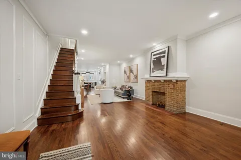 a view of a livingroom with wooden floor and a fireplace