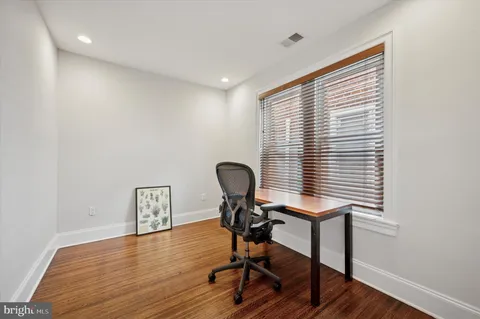 a view of a workspace with furniture and a window