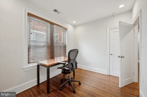 a view of a workspace with furniture and a window
