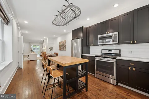 a kitchen with a table chairs microwave and cabinets
