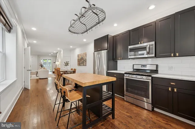 a kitchen with a table chairs microwave and cabinets
