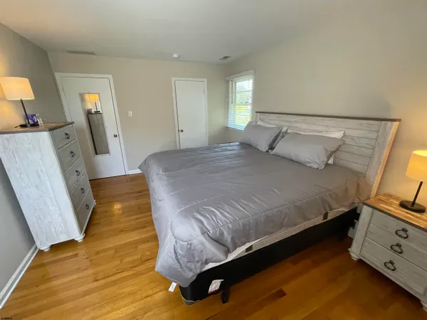 a bedroom with a bed and a flat tv screen on dresser