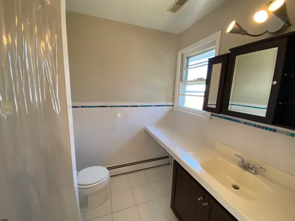a bathroom with a sink a toilet and mirror
