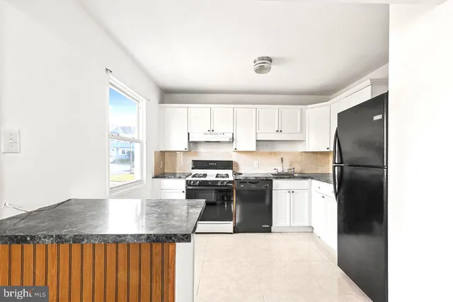 a kitchen with stainless steel appliances granite countertop a refrigerator a stove a sink and a microwave