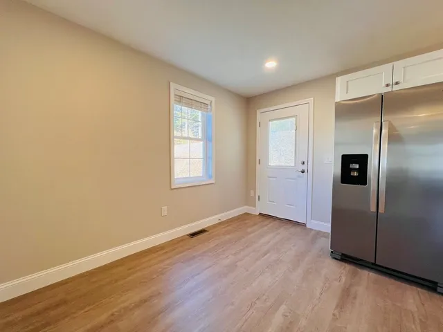 an empty room with wooden floor and a window