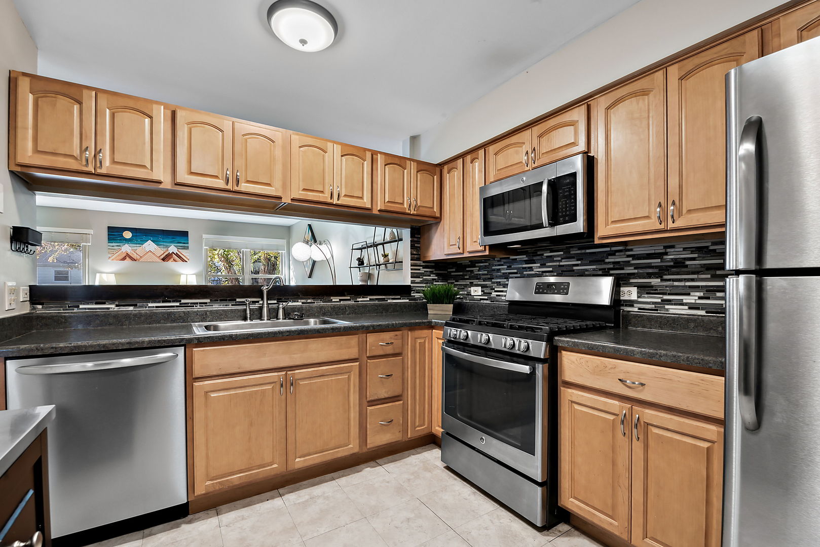 986 Ridgefield Lane Wheeling, IL 60090 - Photo 5 of 17 a kitchen with stainless steel appliances granite countertop a stove top oven a sink dishwasher and cabinets with wooden floor