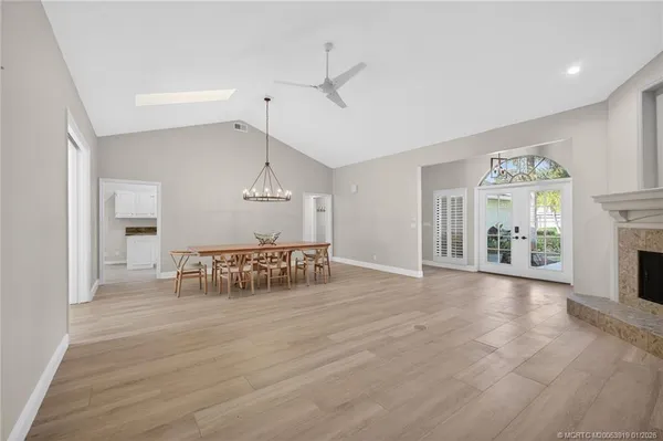 a dining room with furniture a chandelier and wooden floor