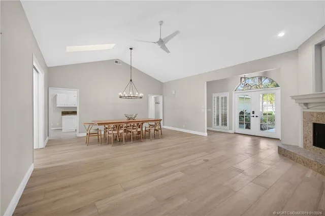 a dining room with furniture a chandelier and wooden floor