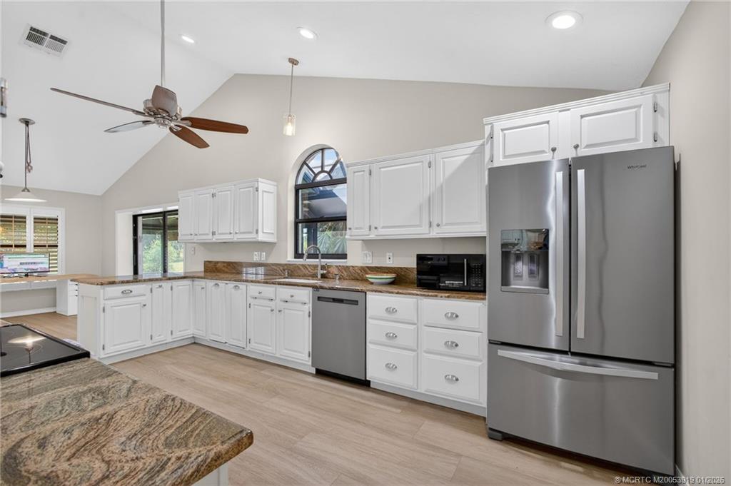 3211 Southeast Court Drive Stuart, FL 34997 - Photo 20 of 60 a kitchen with white cabinets and stainless steel appliances
