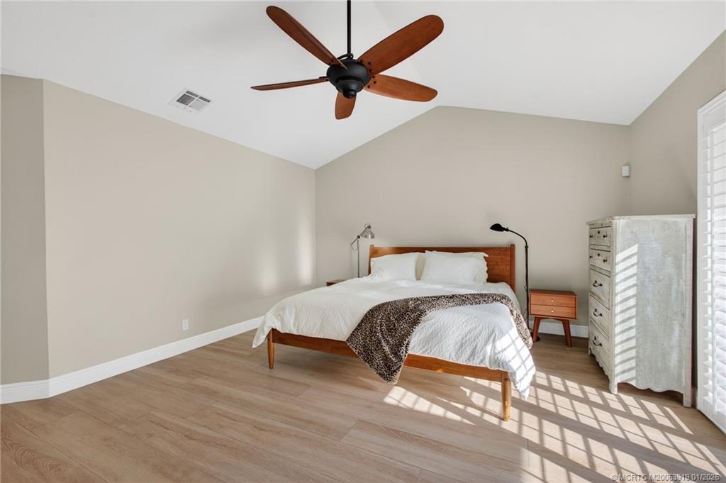 3211 Southeast Court Drive Stuart, FL 34997 - Photo 32 of 60 a bedroom with a bed and a ceiling fan