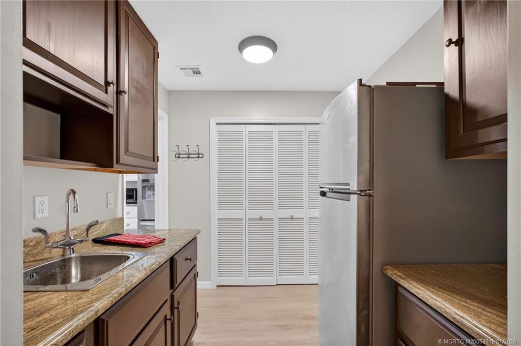 3211 Southeast Court Drive Stuart, FL 34997 - Photo 42 of 60 a kitchen with stainless steel appliances granite countertop a refrigerator and a sink