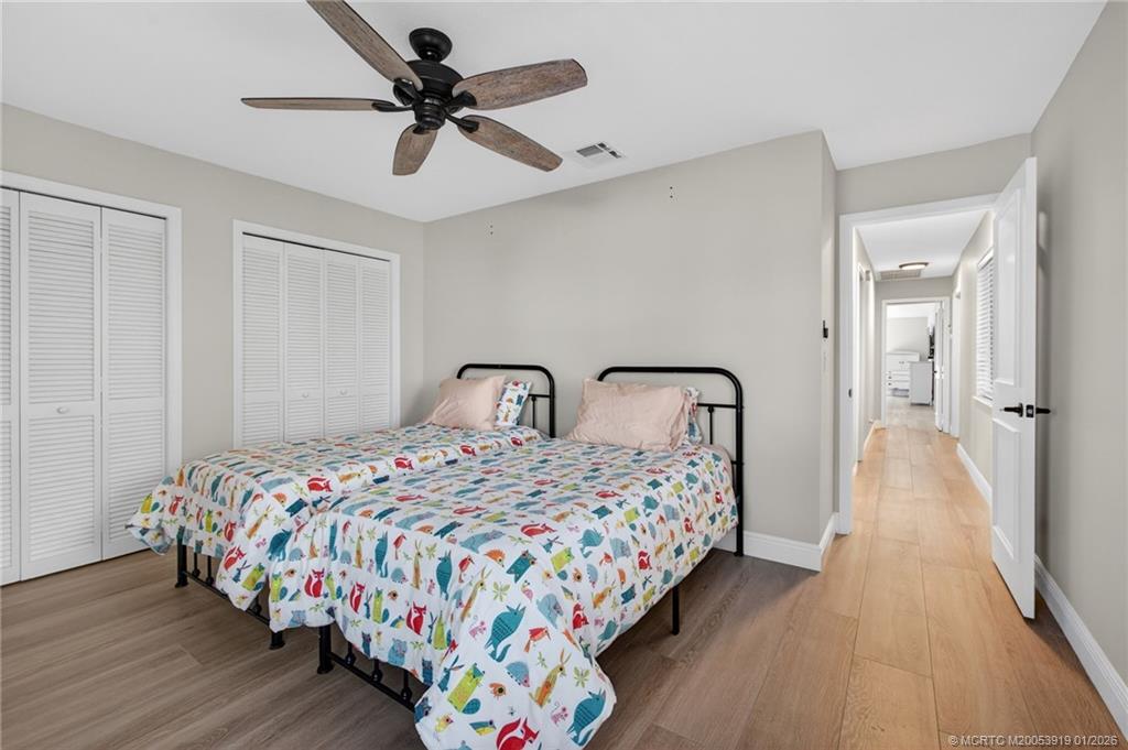 3211 Southeast Court Drive Stuart, FL 34997 - Photo 45 of 60 a bedroom with two beds and a chandelier