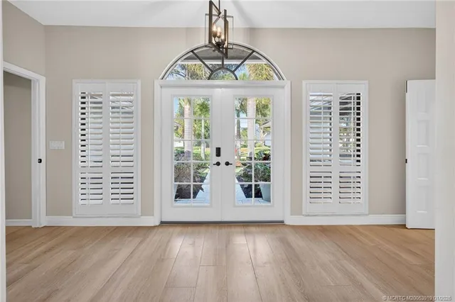 a view of a dining room and livingroom with furniture wooden floor a chandelier