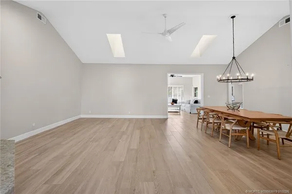 a view of an empty room with wooden floor fireplace and a window