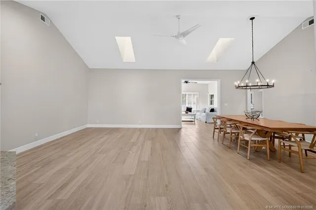 a view of an empty room with wooden floor fireplace and a window