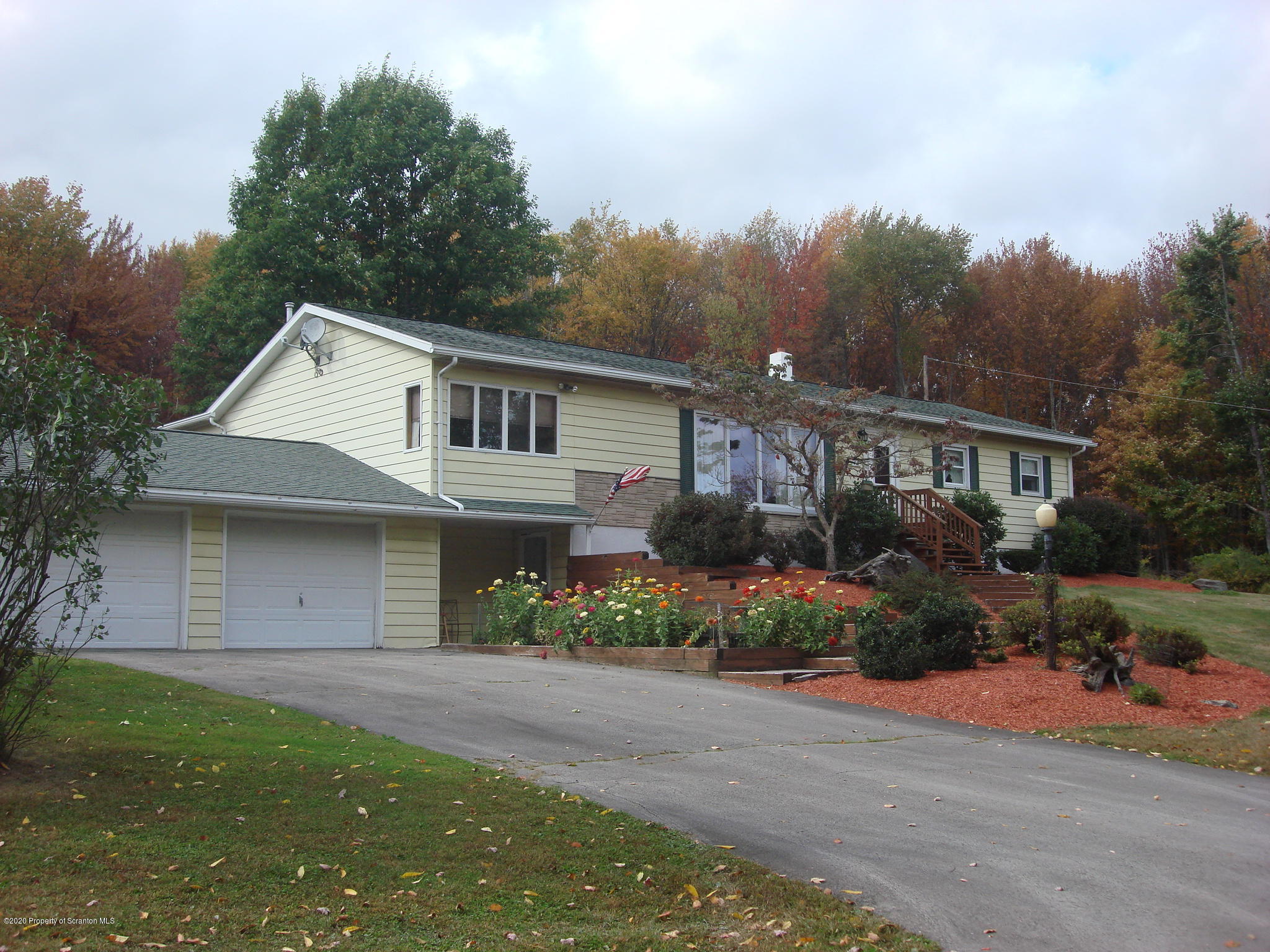 72 Hall Road Laceyville, PA 18623 - Photo 50 of 67 a front view of a house with a garden and trees