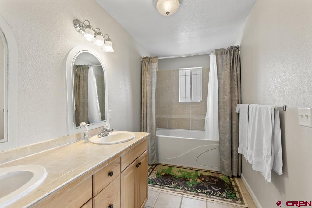19496 E Road Delta, CO 81416 - Photo 17 of 33 a bathroom with a granite countertop sink a toilet and a mirror