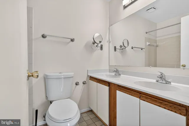 a bathroom with a granite countertop toilet sink and mirror