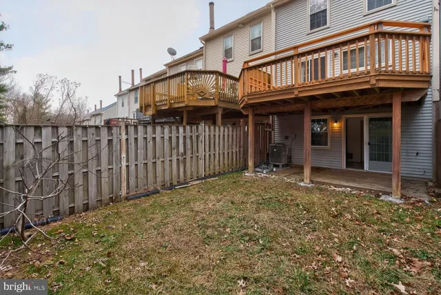 a view of a house with a small yard and wooden fence