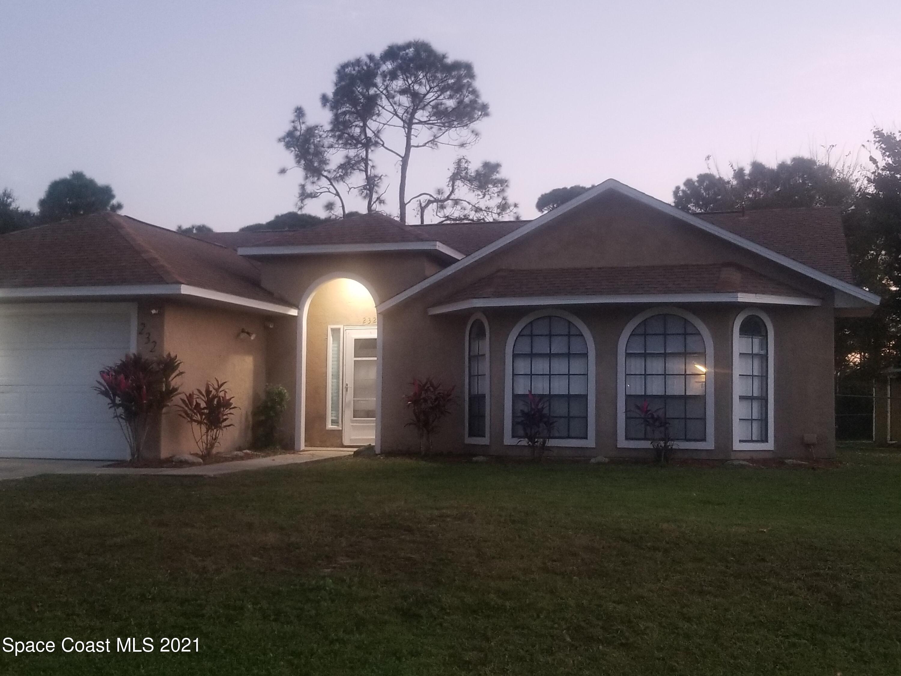 232 Rheine Road Northwest Palm Bay, FL 32907 - Photo 1 of 11 a front view of a house with a garden