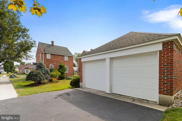 a view of a house with a small yard and a large tree