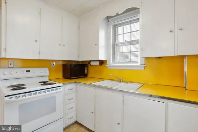 a kitchen with granite countertop cabinets stainless steel appliances and a window