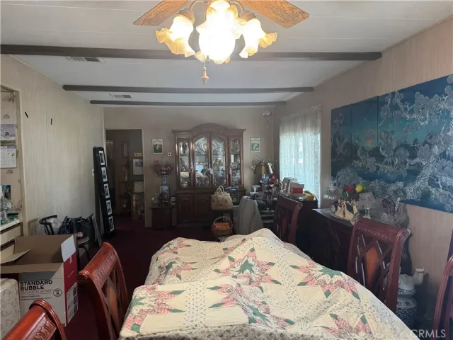 a bedroom with a bed a chandelier and dresser