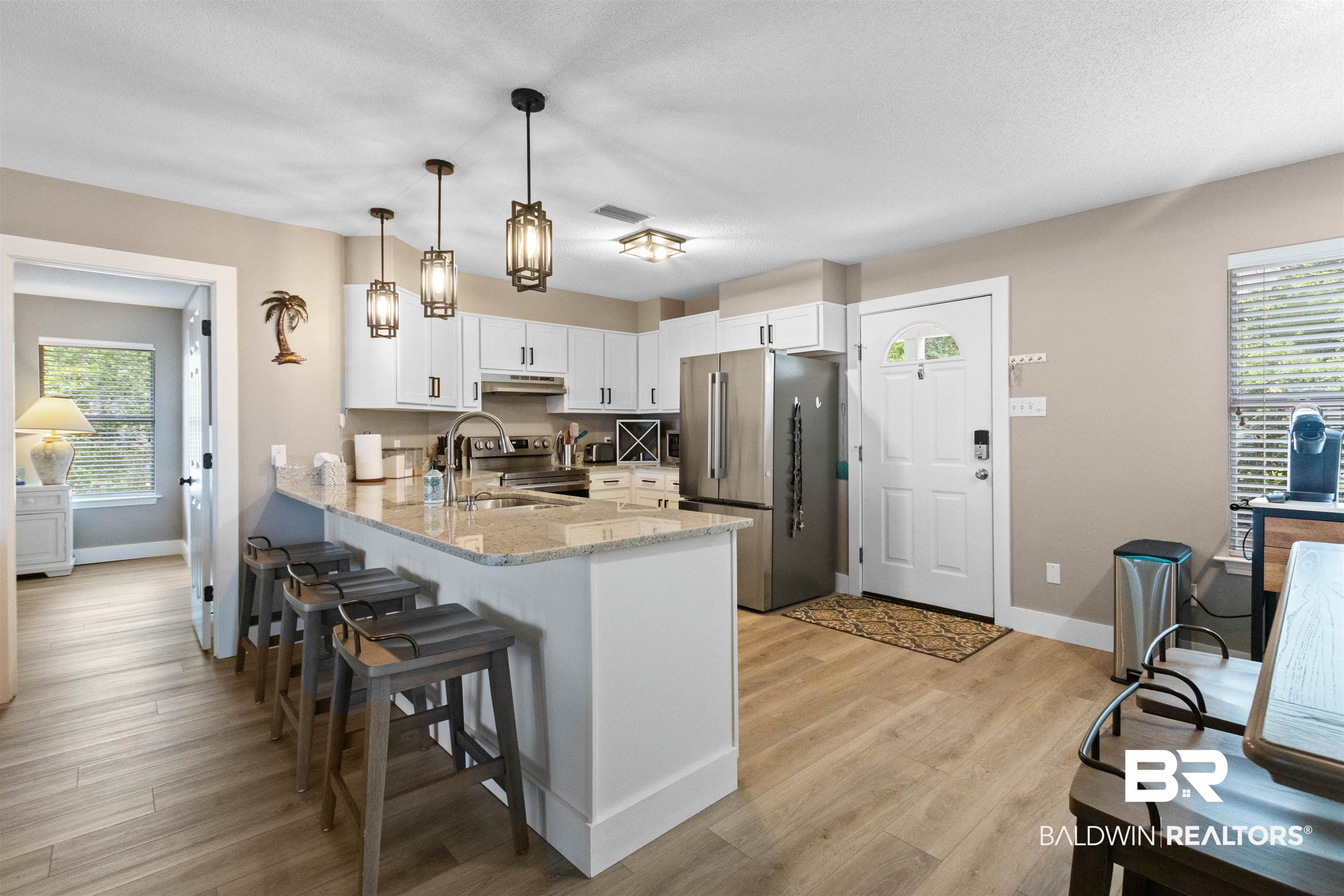 9581 South Bay Street Foley, AL 36535 - Photo 15 of 44 Contemporary kitchen featuring light wood-finish flooring and a stone countertop island with seating