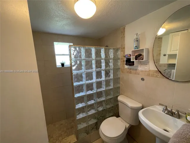 a bathroom with a toilet a sink and mirror