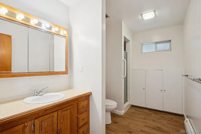 a bathroom with a granite countertop sink toilet and shower