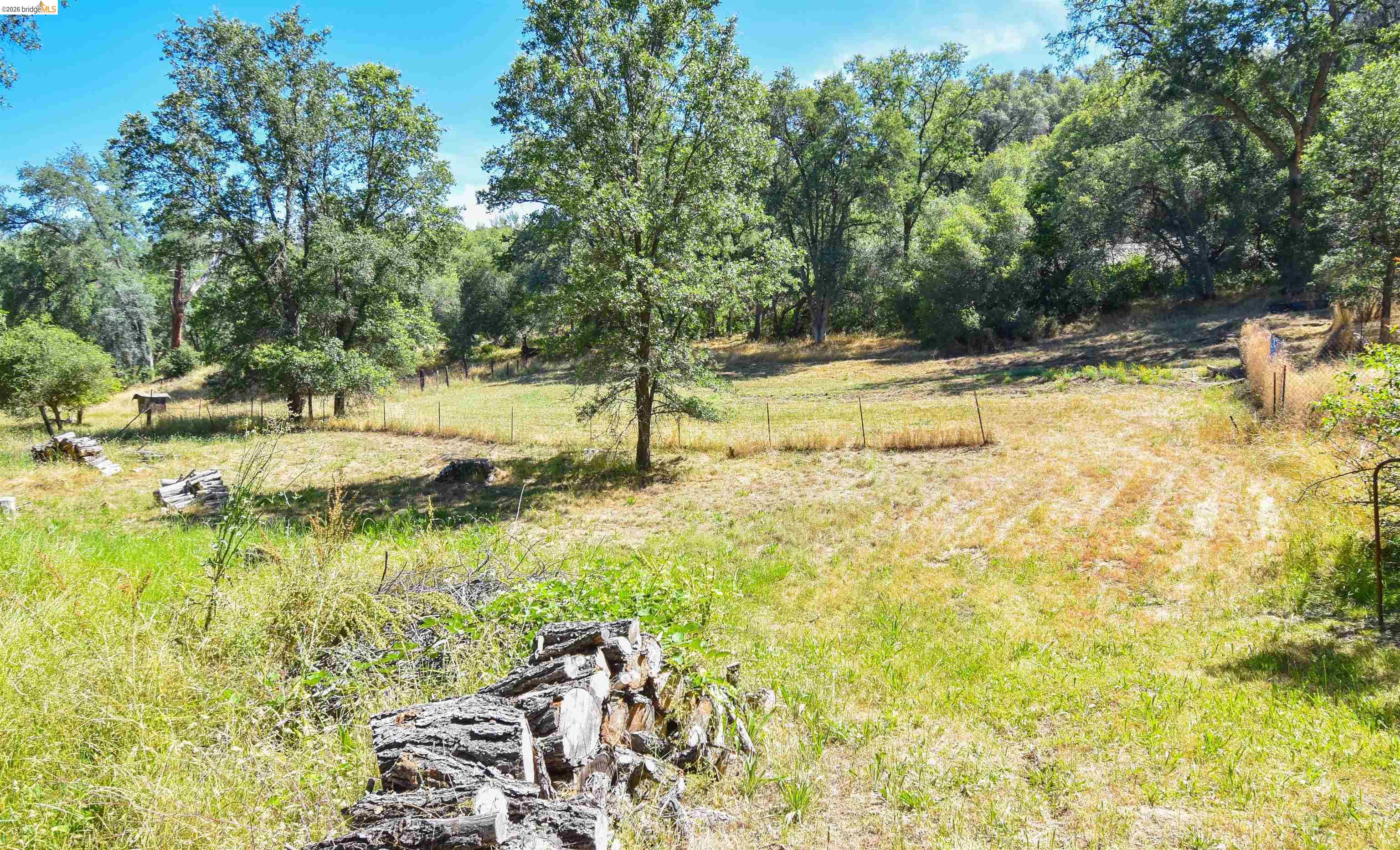 13904 Tuolumne Road Sonora, CA 95370 - Photo 35 of 44 Expansive natural landscape featuring a mix of mature trees, open grassy areas, and partial fencing