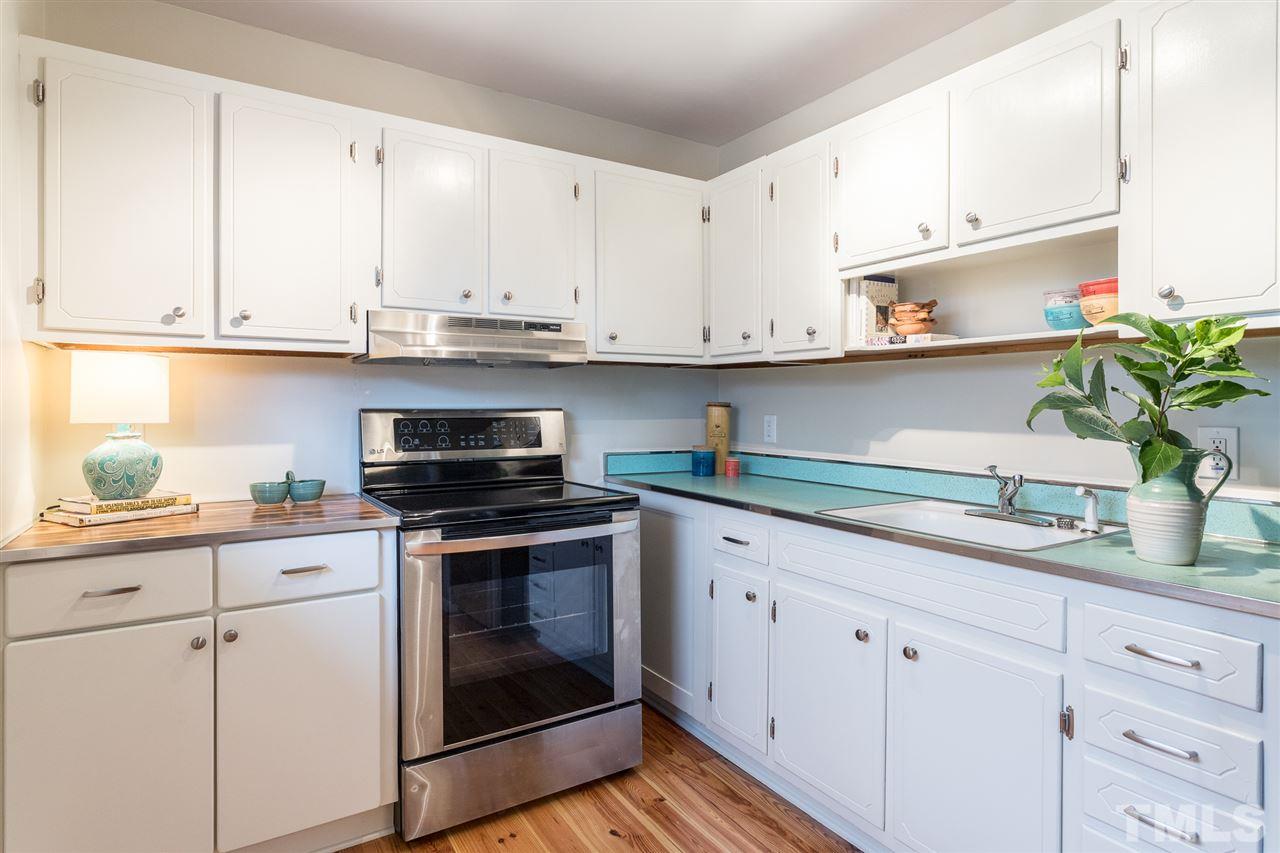 744 Fitzgerald Drive Raleigh, NC 27610 - Photo 11 of 28 a kitchen with granite countertop white cabinets white appliances and a sink