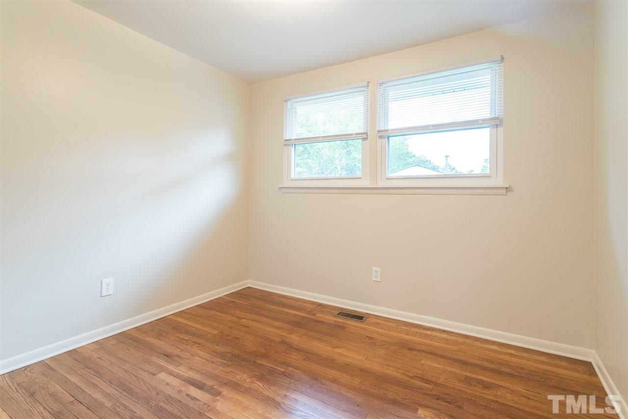 744 Fitzgerald Drive Raleigh, NC 27610 - Photo 13 of 28 an empty room with wooden floor and windows