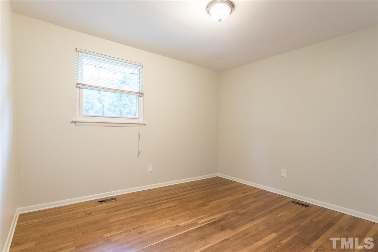 744 Fitzgerald Drive Raleigh, NC 27610 - Photo 15 of 28 an empty room with wooden floor and windows