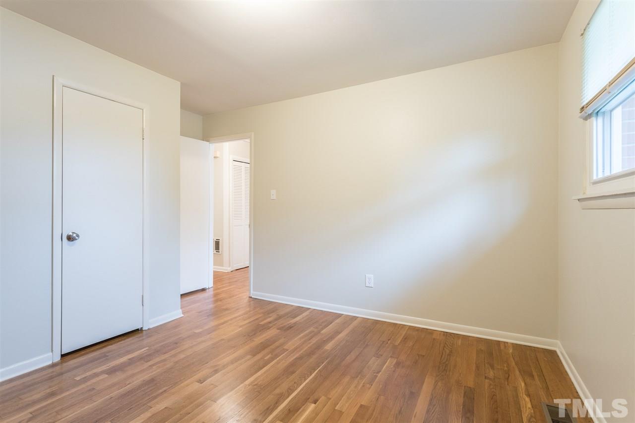 744 Fitzgerald Drive Raleigh, NC 27610 - Photo 16 of 28 a view of an empty room with wooden floor and a window