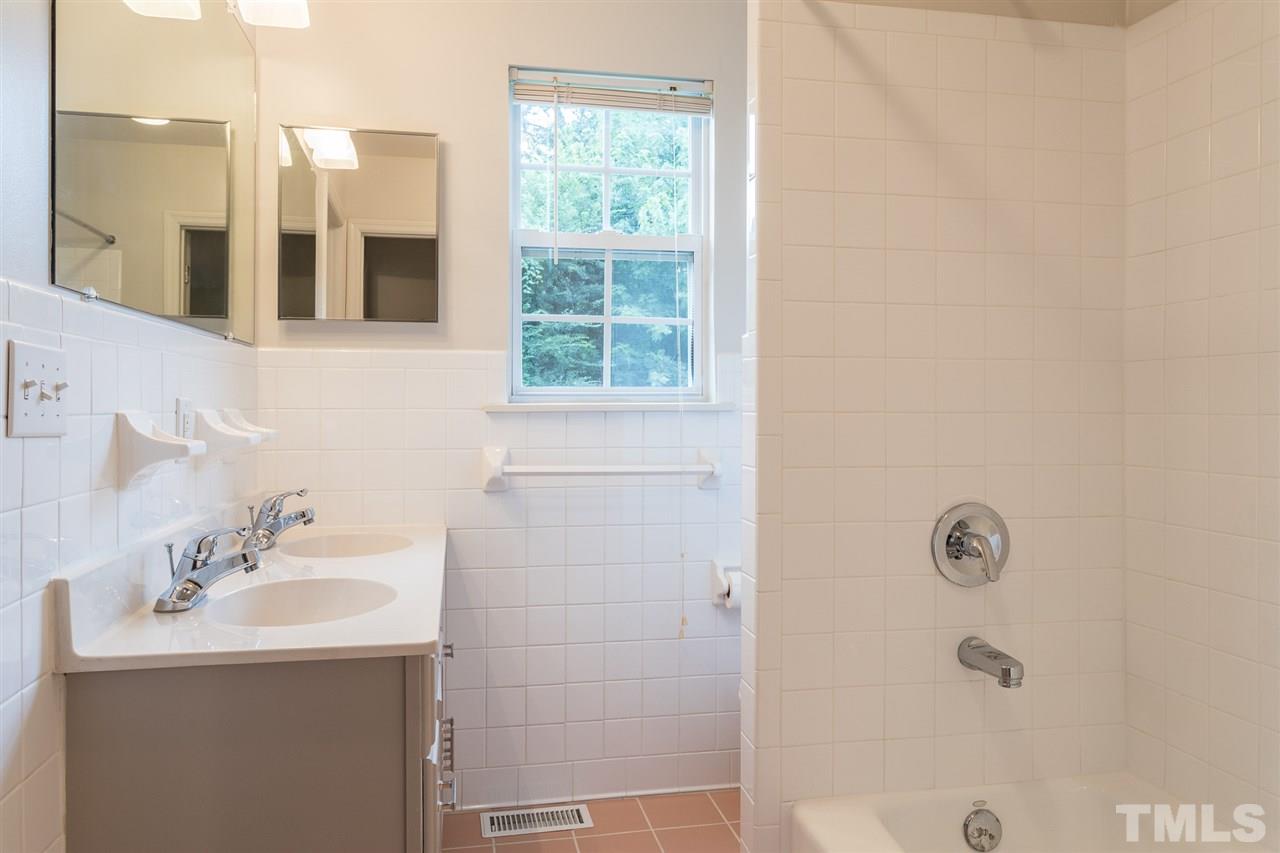 744 Fitzgerald Drive Raleigh, NC 27610 - Photo 22 of 28 a bathroom with a sink a mirror and a shower