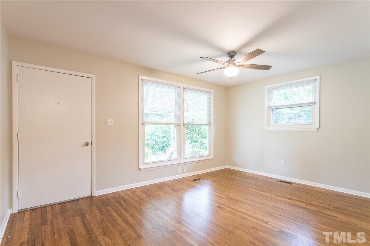 744 Fitzgerald Drive Raleigh, NC 27610 - Photo 4 of 28 an empty room with wooden floor and windows