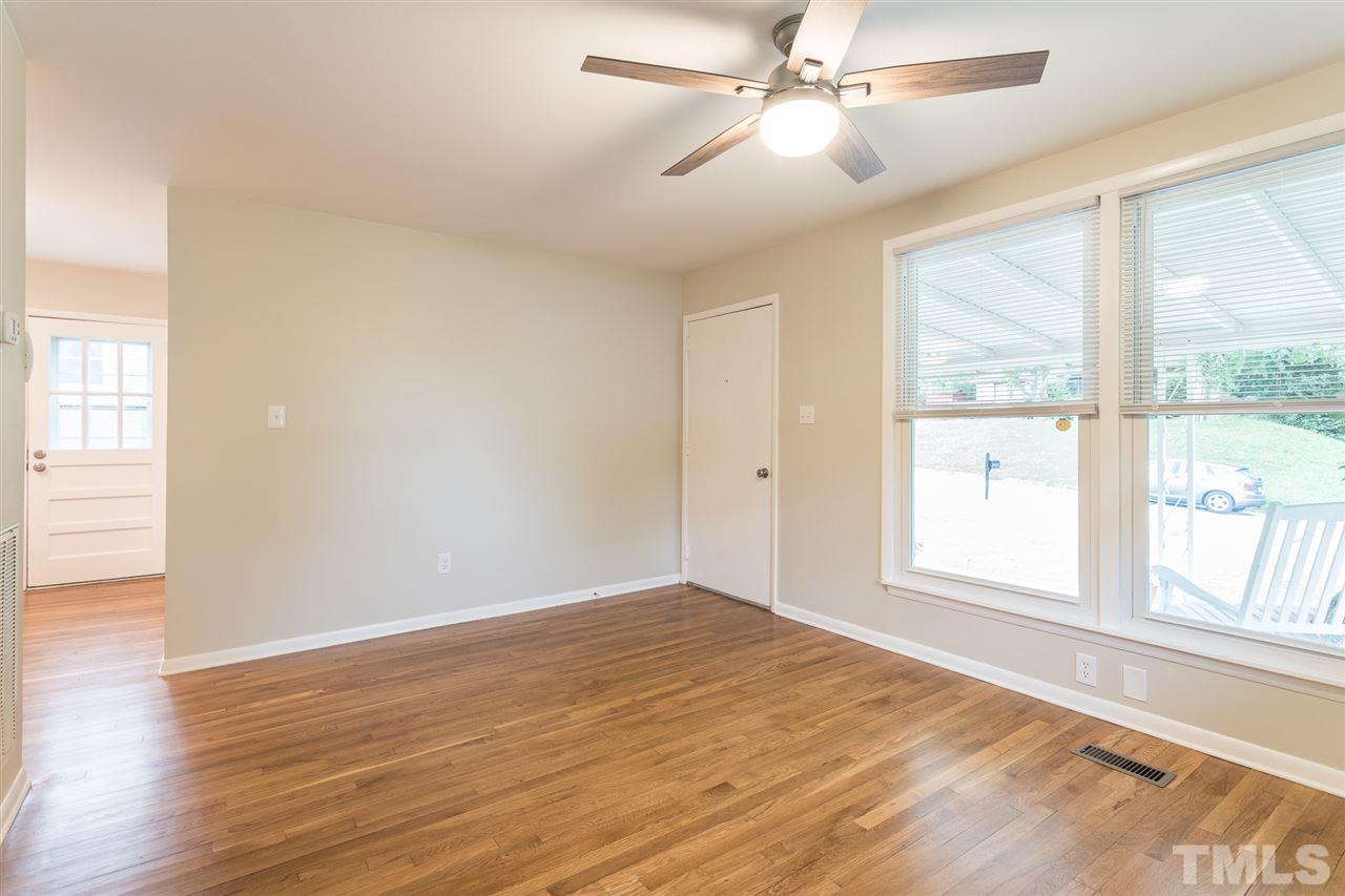 744 Fitzgerald Drive Raleigh, NC 27610 - Photo 6 of 28 an empty room with wooden floor fan and windows