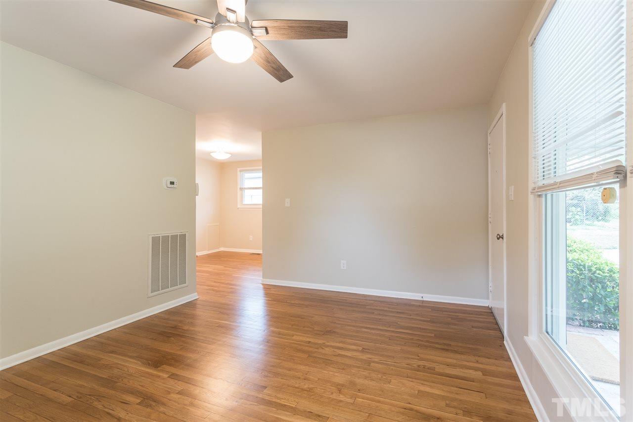 744 Fitzgerald Drive Raleigh, NC 27610 - Photo 7 of 28 a view of an empty room with wooden floor and a window