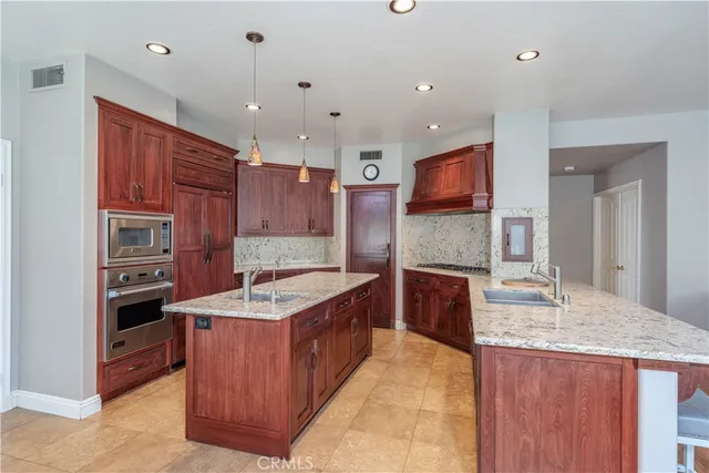 a kitchen with granite countertop stainless steel appliances wooden cabinet and granite counter tops