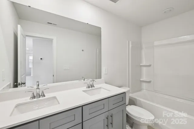 a spacious bathroom with a double vanity sink mirror and double