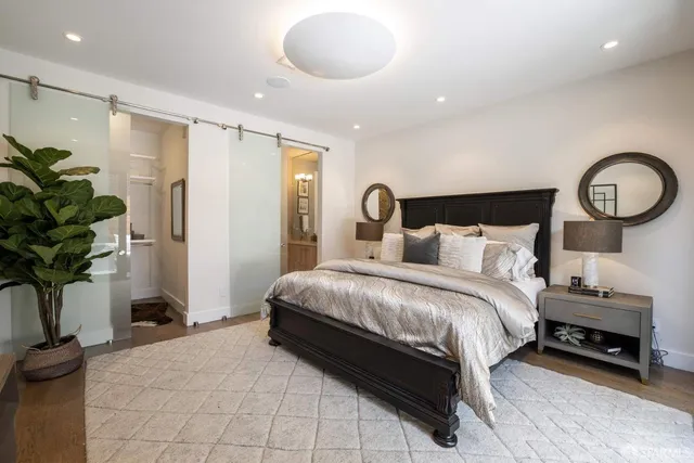 a bedroom with a bed and a potted plant